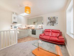 a living room with a red couch and a glass table at Martin - Uk48161 in Filey