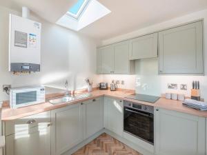 a kitchen with white cabinets and a skylight at Martin - Uk48161 in Filey