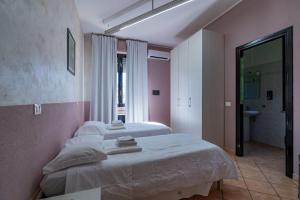 a bedroom with two beds and a bathroom at Locanda San Martino in Collecchio