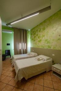 two beds in a room with green walls at Locanda San Martino in Collecchio +10 photos