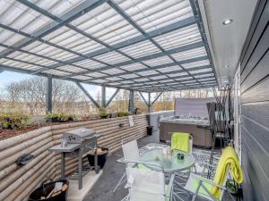 an outdoor patio with a pergola and tables and chairs at Craigpark Lodge in Caldercruix
