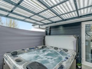 a hot tub sitting on top of a patio at Craigpark Lodge in Caldercruix