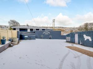a building with a snow covered driveway at Craigpark Lodge in Caldercruix
