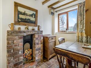 a dining room with a brick fireplace and a table at Shepherds Hut - Uk45529 in Buildwas +8 photos