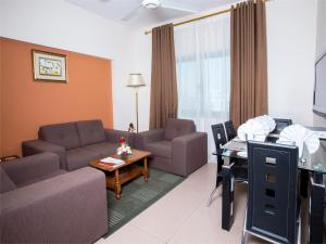 Safeer Plaza Hotel في مسقط: غرفة معيشة مع أريكة وطاولة
