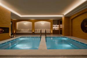 a large swimming pool in a hotel room with a bed at Corinthia Rome in Rome