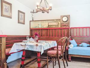 a dining room with a table and chairs and a clock at Apartment Loidl by Interhome in Ebensee