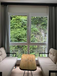 a living room with two chairs and a large window at Pine Suit in Çamlıhemşin