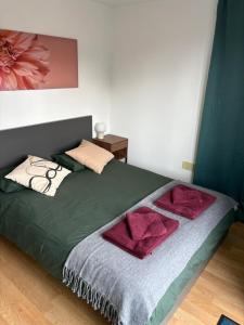 a bedroom with a bed with red pillows on it at Bright and Modern Forest Hill Flat - Flexible Stay in Forest Hill