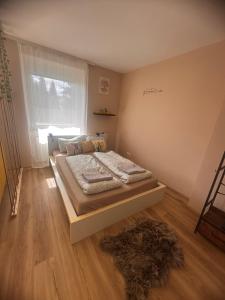 a bedroom with a bed and a window and a rug at Smile Home in Klagenfurt