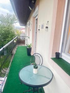 a table and chairs on a balcony with a green floor at Smile Home in Klagenfurt
