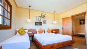 a bedroom with two beds and a desk and a chair at Bio et Bois -Luxury Bio Farm- in Moulay Yacoub