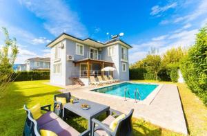 a home with a swimming pool and a house at Villas Dogakent in Ortaca