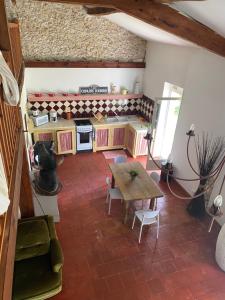 a doll house kitchen with a wooden table and a couch at Gîte Landes d armagnac in Roquefort