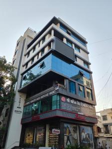 a tall building with a sign in front of it at Nirrtul Crystal 1BHK Apartment Cozy & Quite in Surat