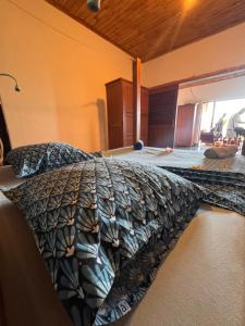 a bedroom with a bed with a comforter on it at Guest House Antsakoa in Nosy Komba