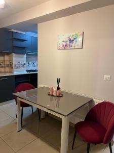 a kitchen with a table and two red chairs at GZP Residence Lugoj 6 in Lugoj