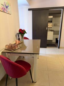 a dining table with red chairs and a laptop on it at GZP Residence Lugoj 6 in Lugoj