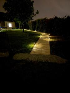 a walkway in a yard at night with lights at Fully equipped, independent apartment in Marles-en-Brie