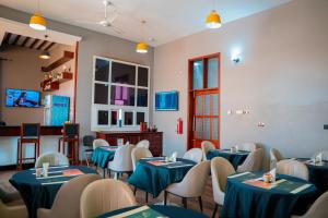 a dining room with blue tables and chairs at Rostel Villa Hotel in Mbeya