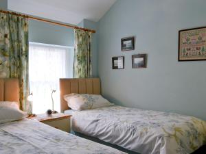 a bedroom with two beds and a window at Cropple Howe in Threlkeld