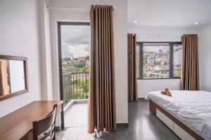 a bedroom with a bed and a large window at Mộc in Ấp Ða Lợi