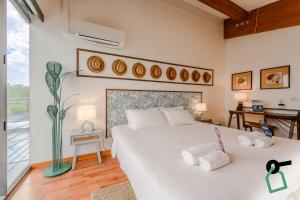 a bedroom with a large white bed with two towels at Hotiday Grado Marina in Grado