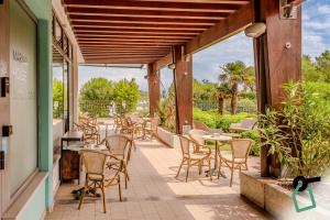 a patio with tables and chairs in a restaurant at Hotiday Grado Marina in Grado
