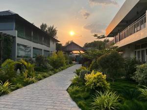 a brick pathway in front of a building with the sunset at The Fox Resort, Bandipur in Bandipūr