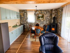 a kitchen with a table and a chair in a room at Gacka Luxury Mountain Villa in Feratovo Polje