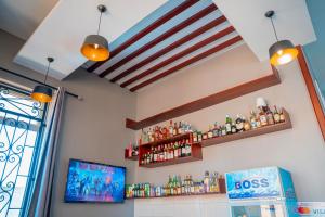 a bar with a bunch of bottles on a wall at Rostel Villa Hotel in Mbeya