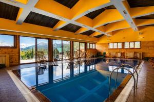 a large indoor pool with chairs in a building at Gacka Luxury Mountain Villa in Feratovo Polje