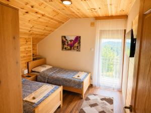 a bedroom with two beds and a window at Gacka Luxury Mountain Villa in Feratovo Polje +6 photos