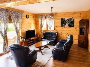 a living room with leather chairs and a television at Gacka Luxury Mountain Villa in Feratovo Polje