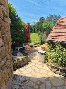 a patio with an umbrella and a table and chairs at Chambre de la Tour 2 in Milhac