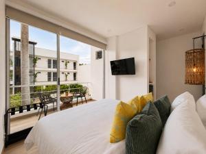 a bedroom with a white bed and a large window at Palmará Hotel in Villeta
