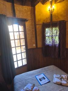 a bedroom with a bed and a window with a book on it at Chambre de la Tour 2 in Milhac