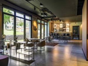 a large room with tables and chairs and windows at ibis Styles Friedrichshafen in Friedrichshafen