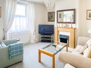 a living room with a fireplace and a tv at St Anne's Cottage in Torquay