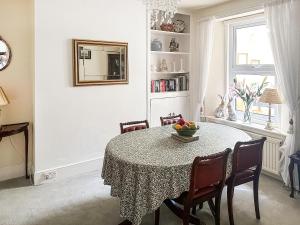 a dining room with a table and chairs and a window at St Anne's Cottage in Torquay