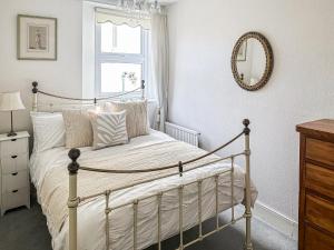 a bedroom with a bed with a mirror on the wall at St Anne's Cottage in Torquay