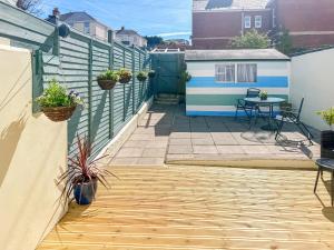 a patio with a fence and a table with plants at St Anne's Cottage in Torquay +1 photo