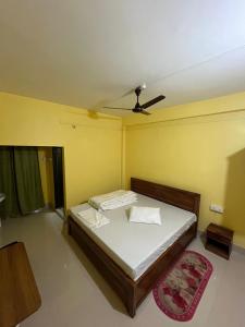 a bedroom with a bed with a ceiling fan at Hotel Diyo inn in Guwahati +7 photos