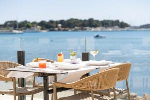 a table with chairs and a view of the water at Visula Hotel & Spa - New Opening 2026 in Medulin