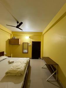a bedroom with a bed and a ceiling fan at Hotel Diyo inn in Guwahati