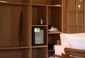 ein Wohnzimmer mit Fernseher und Sofa in der Unterkunft Castello Beach Hotel in Grand'Anse Praslin