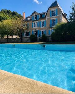 a large swimming pool in front of a house at Le clos joli in Saint-Saviol