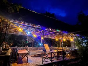 a patio with chairs and lights at night at Kisoro Suits in Kisoro