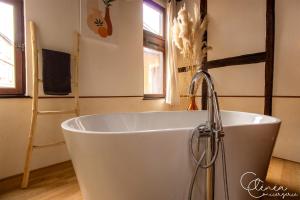 a white bath tub in a bathroom with a faucet at Sous les toits de Sainte-Cécile in Albi +9 photos