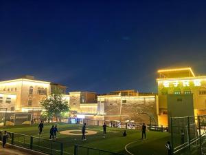 a group of people on a campus at night at 巷子民宿 in Kashgar